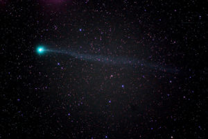An astrophoto of the Lovejoy Comet, which was captured by Kendra Watkins' grandfather, William Nigg. The photo captures a vast darkness speckled with countless small stars, and a turquoise comet streaks from right to left across the cosmos.